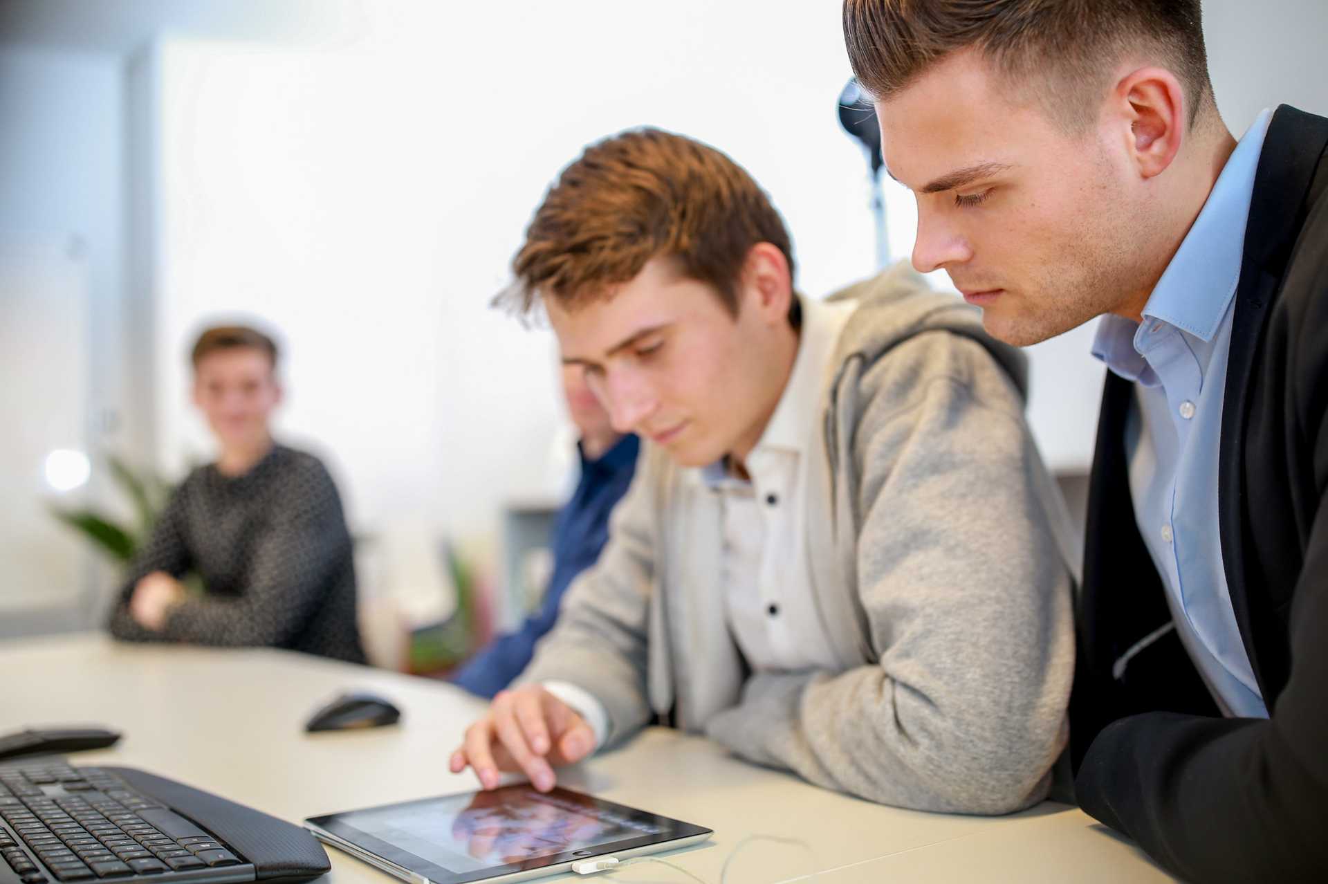 Ein Incoqnito Mitarbeiter und unser CEO schauen gemeinsam auf ein Tablet